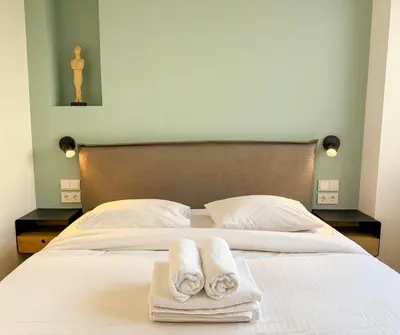 a bed with two towels on top of it at Syntagma Spacious Residence in Athens