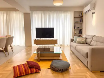 a living room with a couch and a flat screen tv at Syntagma Spacious Residence in Athens