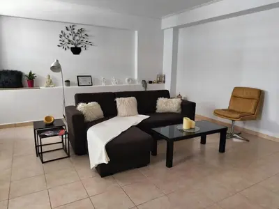 a living room with a black couch and a table at Charming Flat in Central Athens in Athens