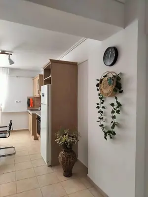 a kitchen with a refrigerator and a clock on the wall at Charming Flat in Central Athens in Athens