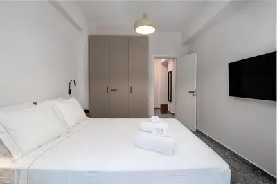 a bedroom with a white bed with towels on it at Stylish Retreat in Quiet Piraeus Newly Renovated in Piraeus