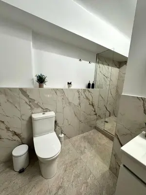 a white bathroom with a toilet and a shower at Athenian Stay 601 Apartment in Athens