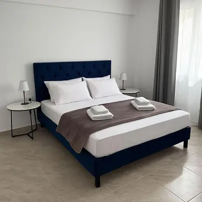 a bedroom with a blue bed with two tables at Athenian Stay 605 Apartment in Athens