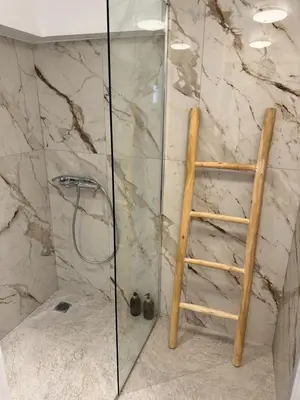 a glass shower with a ladder in a bathroom at Athenian Stay 605 Apartment in Athens