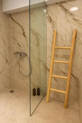a glass shower with a wooden ladder in a bathroom at Athenian Stay 605 Apartment in Athens