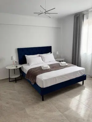 a bedroom with a large blue bed with two tables at Athenian Stay 605 Apartment in Athens
