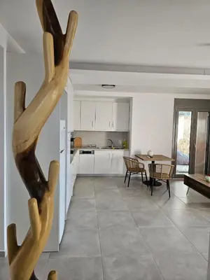 a kitchen and a living room with a table at Olive Ridge in Porto Rafti