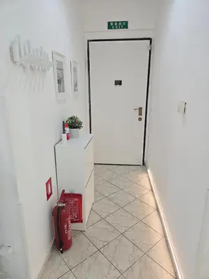 a hallway with a white door and a red suitcase at Acropolis Dream Apartment - 50sqm 2BR Big Living Room with Large Terrace Next to Siggrou FIX Subway Station in the City Center in Athens