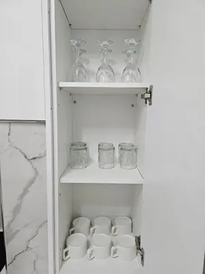 a cupboard with glasses and bowls on shelves at Acropolis Dream Apartment - 50sqm 2BR Big Living Room with Large Terrace Next to Siggrou FIX Subway Station in the City Center in Athens