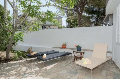 a patio with two chairs and a table and a fence at Stef's Place Porto Rafti in Porto Rafti