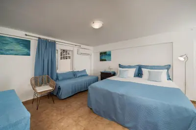 a bedroom with a blue bed and a blue couch at Stef's Place Porto Rafti in Porto Rafti