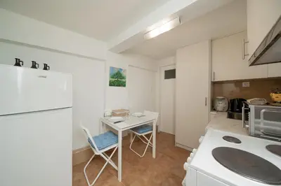 a kitchen with a white refrigerator and a table at Stef's Place Porto Rafti in Porto Rafti