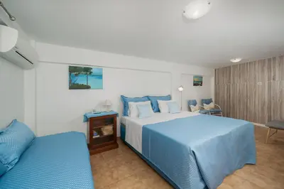 a bedroom with a blue bed and a couch at Stef's Place Porto Rafti in Porto Rafti