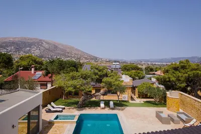 a villa with a swimming pool and a house at Aeolia Villa Athenian Riviera in Anavissos