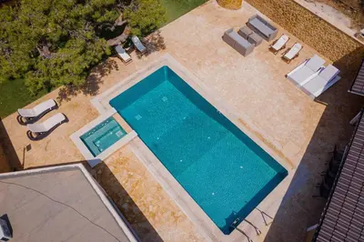 an overhead view of a swimming pool with chaises and chairs at Aeolia Villa Athenian Riviera in Anavissos