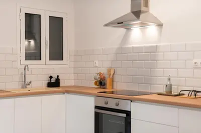 a kitchen with white cabinets and a stove top oven at 2BR Modern Comfort Top Location in Athens