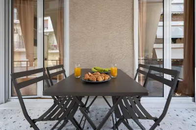 a table with a plate of food and two glasses of orange juice at 2BR Modern Comfort Top Location in Athens