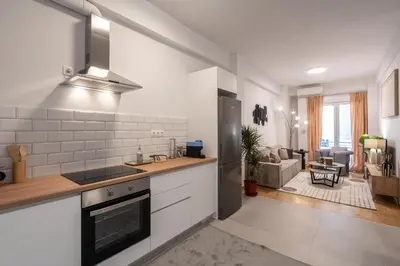 a kitchen with a stove top oven next to a living room at 2BR Modern Comfort Top Location in Athens