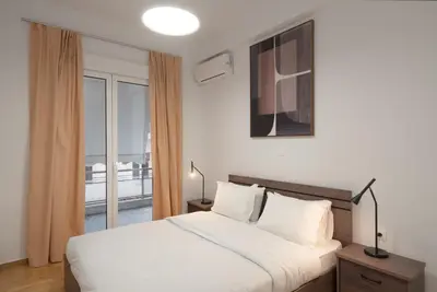 a bedroom with a white bed and a balcony at 2BR Modern Comfort Top Location in Athens