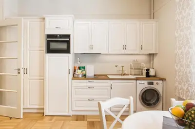 a kitchen with white cabinets and a dishwasher at Restored Historic APT in Plaka,Under the Acropolis in Athens