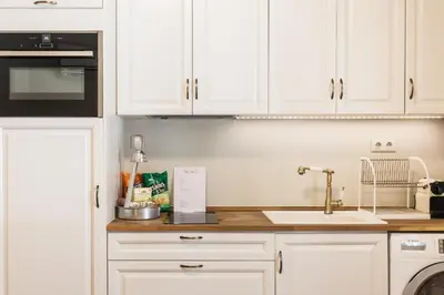 a kitchen with white cabinets and a sink at Restored Historic APT in Plaka,Under the Acropolis in Athens