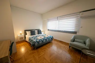 a bedroom with a bed and a chair and a window at Comfy 2BR Flat in Central Athens in Athens