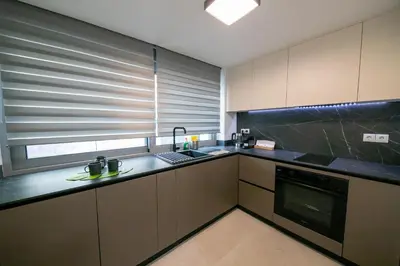 a kitchen with a sink and a window with blinds at Comfy 2BR Flat in Central Athens in Athens