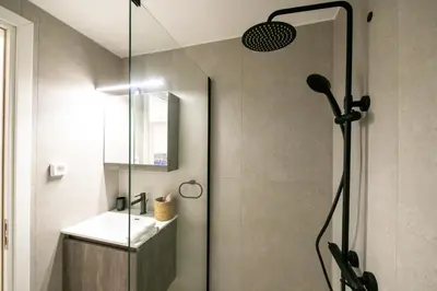 a bathroom with a shower with a sink and a glass shower door at Comfy 2BR Flat in Central Athens in Athens