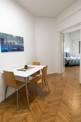 a dining room with a white table and chairs at Comfy 2BR Flat in Central Athens in Athens