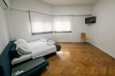 a bedroom with a bed and a wooden floor at Comfy 2BR Flat in Central Athens in Athens
