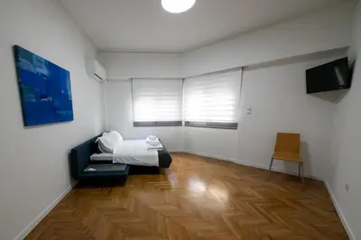 a bedroom with a bed and a wooden floor at Comfy 2BR Flat in Central Athens in Athens