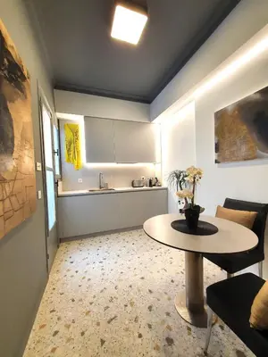 a living room with a table and a kitchen at Art Gallery Apartment in Athens