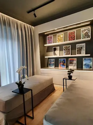 a bedroom with two beds and two tables with flowers at Art Gallery Apartment in Athens