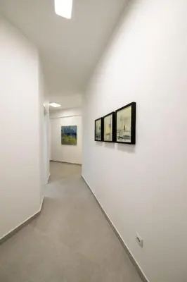 a hallway with three paintings on a wall at Smoothie 2Bdr City Center Flat in Athens