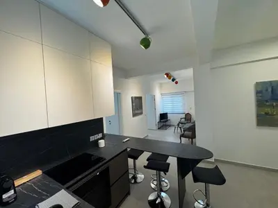 a kitchen with a black counter top and a table at Smoothie 2Bdr City Center Flat in Athens