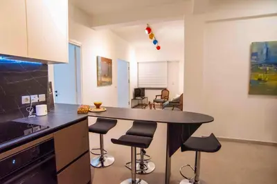 a kitchen with a counter and bar stools at Smoothie 2Bdr City Center Flat in Athens