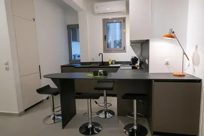 a kitchen with a large black island with bar stools at Smoothie 2Bdr City Center Flat in Athens