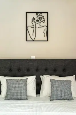 a bedroom with a bed with two pictures on the wall at Artemis Modern Apartment II in Athens