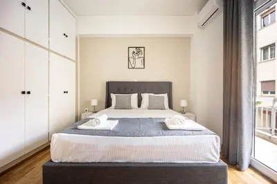 a bedroom with a large bed with two towels at Artemis Modern Apartment II in Athens