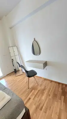 a white room with a chair and a mirror at Artemis Modern Apartment II in Athens