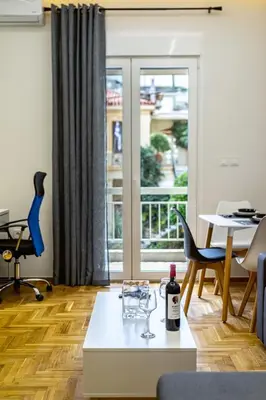 a living room with a table with a wine glass on it at Artemis Modern Apartment II in Athens