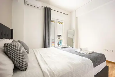 a bedroom with two beds and a window at Artemis Modern Apartment II in Athens
