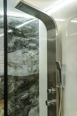 a shower in a bathroom with a stone wall at Artemis Modern Apartment II in Athens