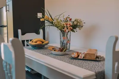 a table with a vase of flowers and a plate of food at Alexander Home in Vravrona