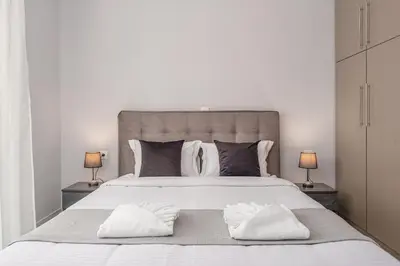 a bedroom with a large white bed with two pillows at Alexander Home in Vravrona
