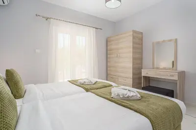 a bedroom with a large white bed with a mirror at Alexander Home in Vravrona