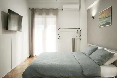 a bedroom with a large bed and a window at Velora Apartments in Athens