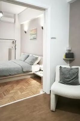 a bedroom with a bed and a chair at Velora Apartments in Athens