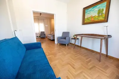 a living room with a blue couch and a table at 5th floor Apt with Acropolis view in Pangrati in Athens
