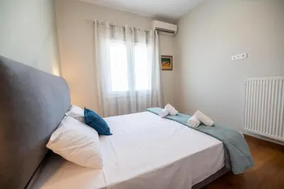 a bedroom with a white bed with blue pillows on it at 5th floor Apt with Acropolis view in Pangrati in Athens